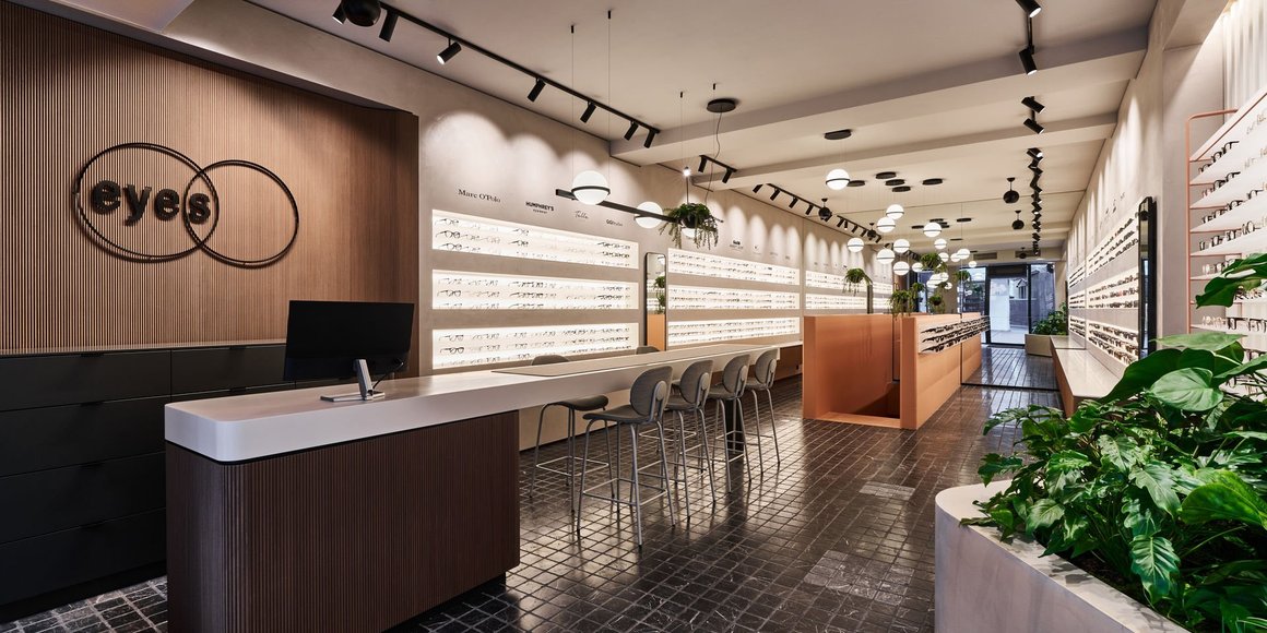 Modernes Optikgeschäft Innenraum mit eyes Logo und Brillendisplays