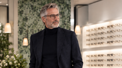 Stilvoller Kunde mit hochwertiger Brille im Optik-Fachgeschäft