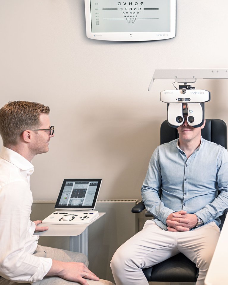 Augenoptiker und Kunde bei einem modernen, hochwertigen Sehtest. Vermessen mit der neuesten Sehtest-Technologie