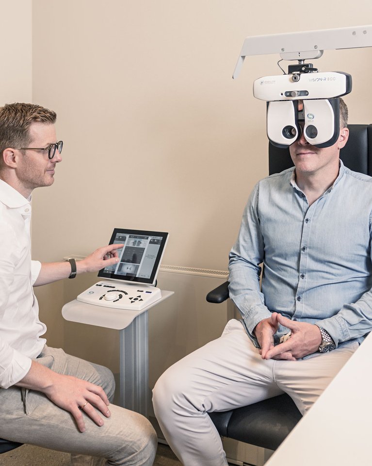 Kunde lässt seine Sehstärke mit einem modernen Augenmessgerät bei einem Optiker überprüfen.