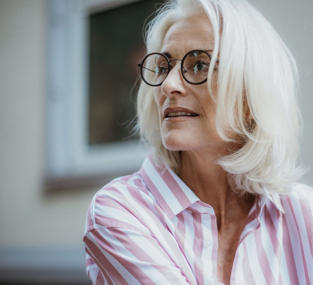 Ältere Frau mit runder Brille im gestreiften Hemd HOFFMANN NATURAL EYEWEAR